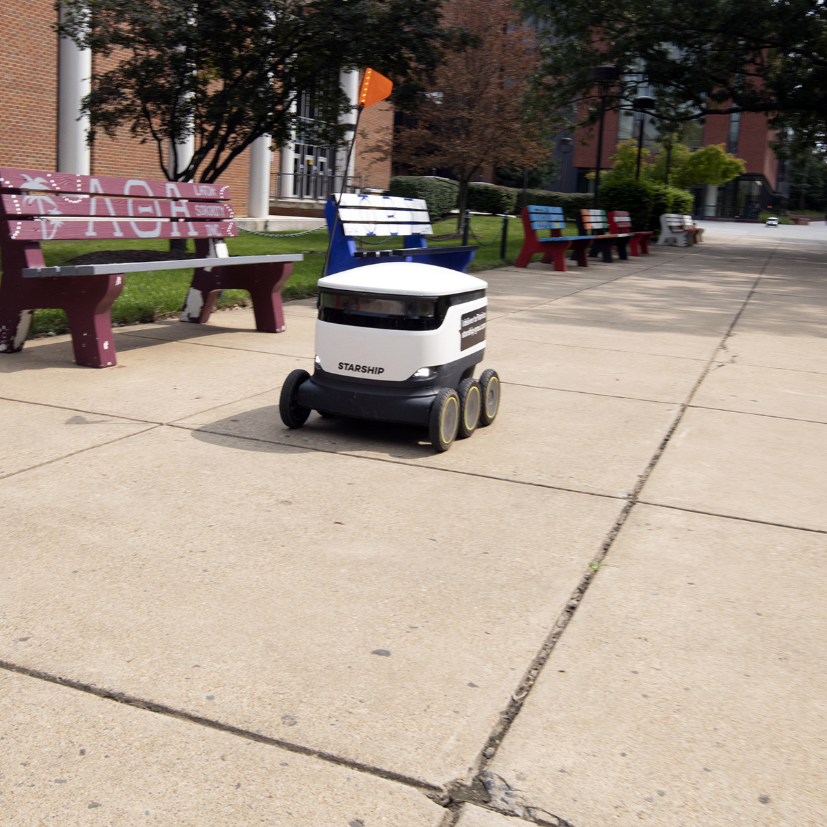 A robotic delivery cart driving through the George Mason campus.